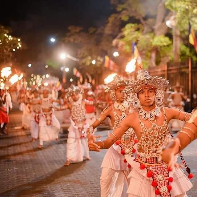 Sri Lankan Kandyan dancers performing in colorful traditional attire.